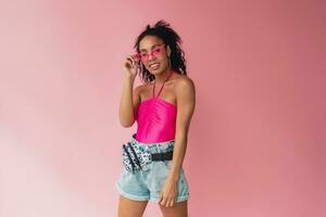 attractive black african american woman in stylish outfit on pink background photo