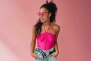 attractive black african american woman in stylish outfit on pink background photo