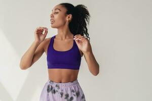 attractive black african american woman in stylish hipster fitness outfit on isolated background photo