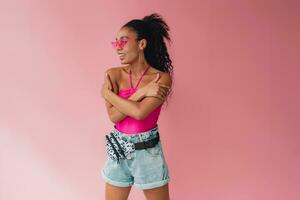 attractive black african american woman in stylish outfit on pink background photo