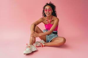 attractive black african american woman in stylish outfit on pink background photo