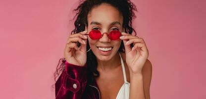 attractive black african american woman in stylish outfit on pink background photo