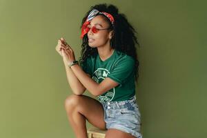 atractivo negro africano americano mujer posando en elegante hipster atuendo en verde antecedentes foto