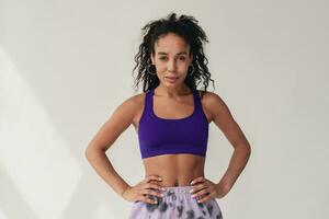 attractive black african american woman in stylish hipster fitness outfit on isolated background photo