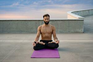 atractivo hansome hombre con atlético fuerte cuerpo haciendo Mañana yoga dzen meditación foto