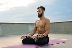 attractive hansome man with athletic strong body doing morning yoga dzen meditation photo