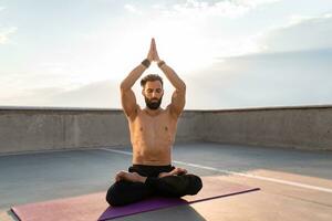 attractive hansome man with athletic strong body doing morning yoga dzen meditation photo