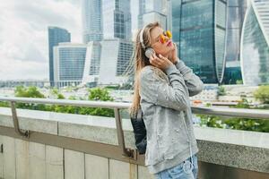 young hipster woman in casual outfit having fun listening to music photo