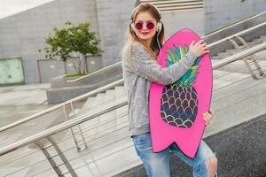 young hipster woman in street with balance board photo