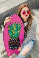 young hipster woman in street with balance board photo