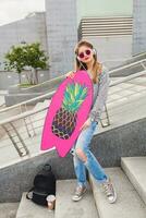 young hipster woman in street with balance board photo