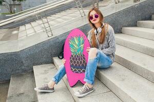 young hipster woman in street with balance board photo