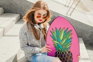 young hipster woman in street with balance board photo