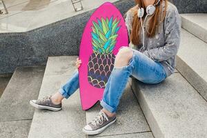 young hipster woman in street with balance board photo