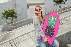 young hipster woman in street with balance board photo