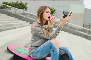 young hipster woman in street with balance board photo