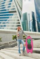 young hipster woman in street with balance board photo