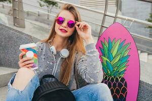 young hipster woman in street with balance board photo