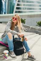 young hipster woman in street with balance board photo