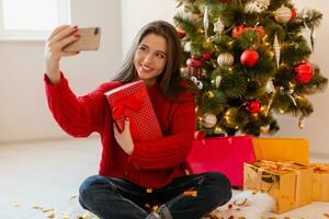 pretty woman at christmas tree with presents photo