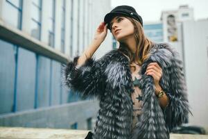 stylish woman in winter fur coat walking in street photo