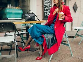 stylish woman in red coat sitting in cafe photo