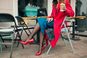 elegante mujer en rojo Saco sentado en café foto