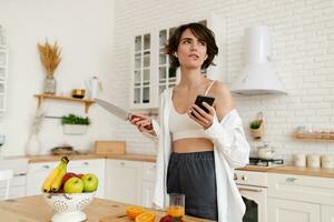 young pretty woman cooking at home, morning kitchen, healthy food photo