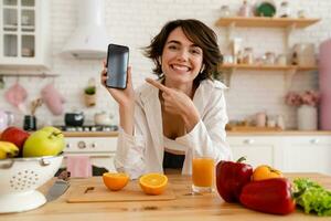 joven bonito mujer Cocinando a hogar, Mañana cocina, sano comida foto