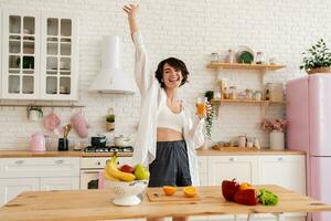 joven bonito mujer Cocinando a hogar, Mañana cocina, sano comida foto