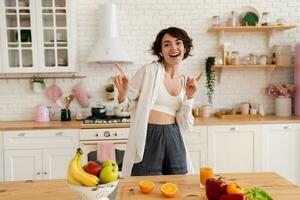 joven bonito mujer Cocinando a hogar, Mañana cocina, sano comida foto