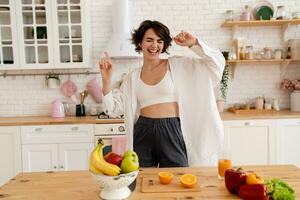 joven bonito mujer Cocinando a hogar, Mañana cocina, sano comida foto