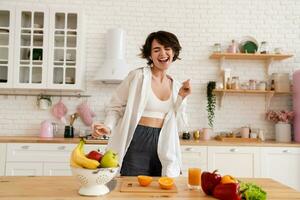 joven bonito mujer Cocinando a hogar, Mañana cocina, sano comida foto