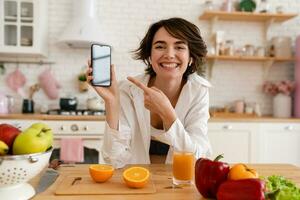 joven bonito mujer Cocinando a hogar, Mañana cocina, sano comida foto