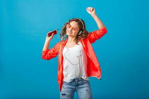 atractivo mujer en alegre salido estado animico escuchando a música en auriculares foto