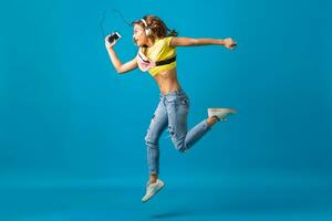 atractivo mujer en alegre salido estado animico escuchando a música en auriculares foto