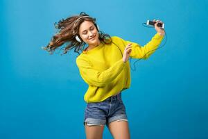 atractivo mujer en alegre salido estado animico escuchando a música en auriculares foto