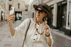 attractive woman walking in shopping street in Italy on vacation dressed in white summer fashion dress photo