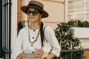 beautiful woman walking in street on vacation dressed in white summer fashion dress photo