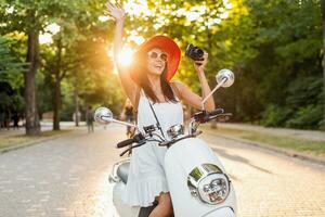 attractive woman riding on motorbike in street photo