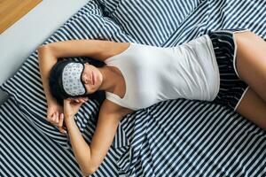 pretty sexy woman lying in bed in morning, wake up early, sleeping in mask photo