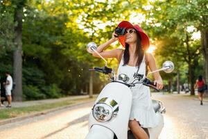 attractive woman riding on motorbike in street photo