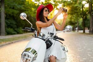 attractive woman riding on motorbike in street photo