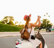 attractive woman riding on motorbike in street photo