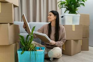 pretty happy woman moving in to new apartment with boxes photo