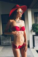 young woman with beautiful slim body wearing red bikini swimsuit photo