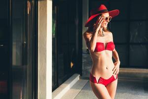 young woman with beautiful slim body wearing red bikini swimsuit photo