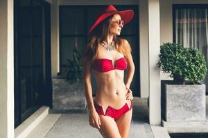 young woman with beautiful slim body wearing red bikini swimsuit photo