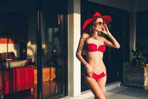 young woman with beautiful slim body wearing red bikini swimsuit photo