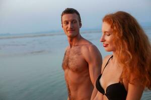 joven romántico Pareja en amor contento en verano playa juntos teniendo divertido vistiendo nadar trajes foto
